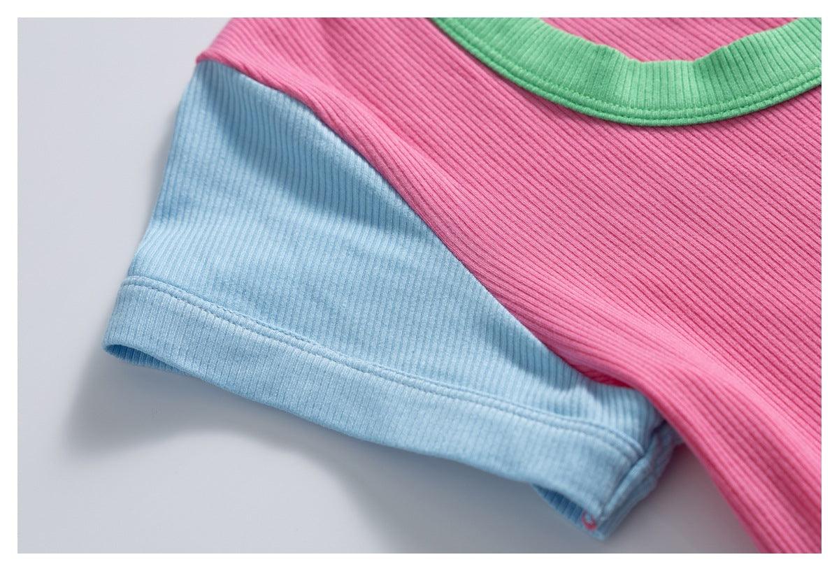 Close-up of the light blue sleeve and pink body of a ribbed shirt with green neckline trim.
