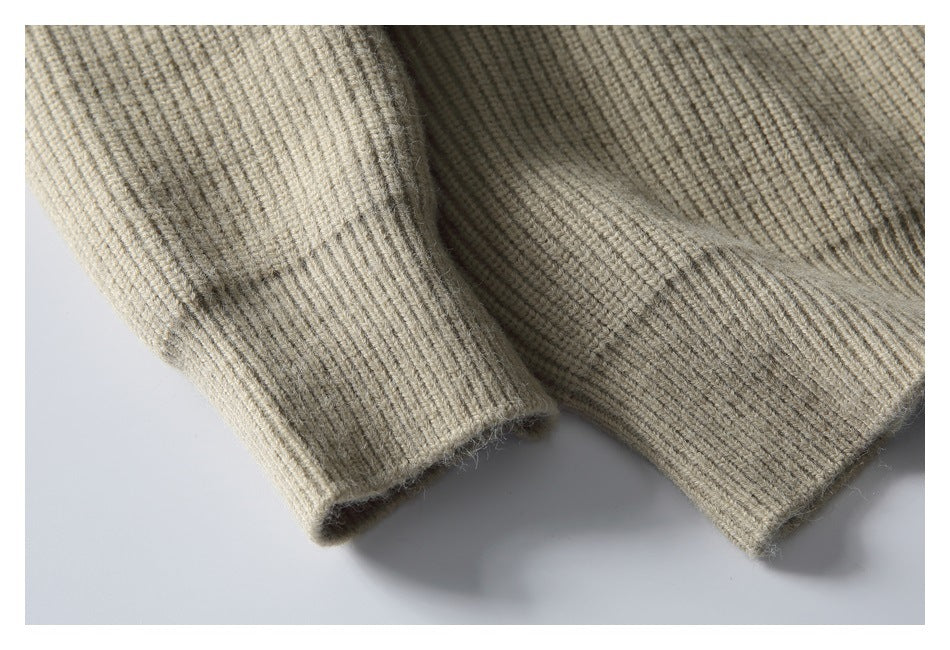 Close-up of a ribbed sleeve cuff and lower hem on a beige knit sweater.