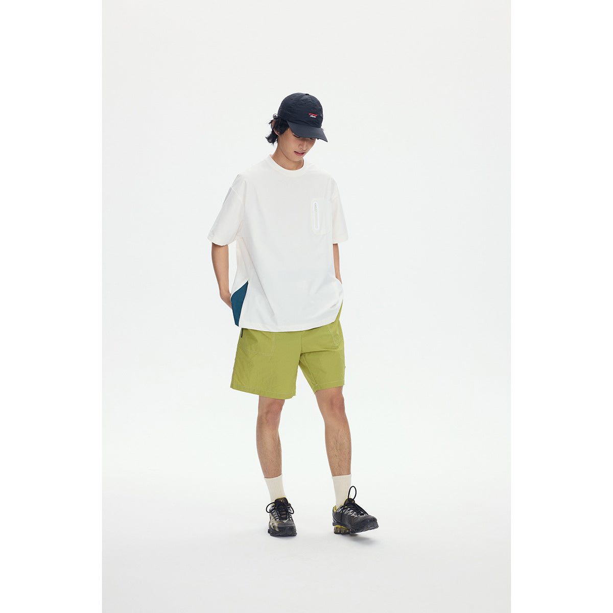 Model wearing an oversized white T-shirt and lime-green shorts with a small chest pocket.