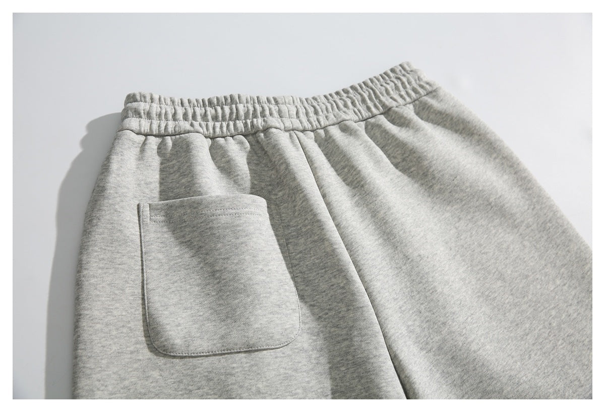 Close-up of gray heather shorts with an elastic waistband and a large front patch pocket.