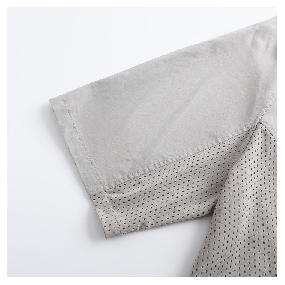 Close-up of a light gray short sleeve with a perforated mesh panel along its lower section.