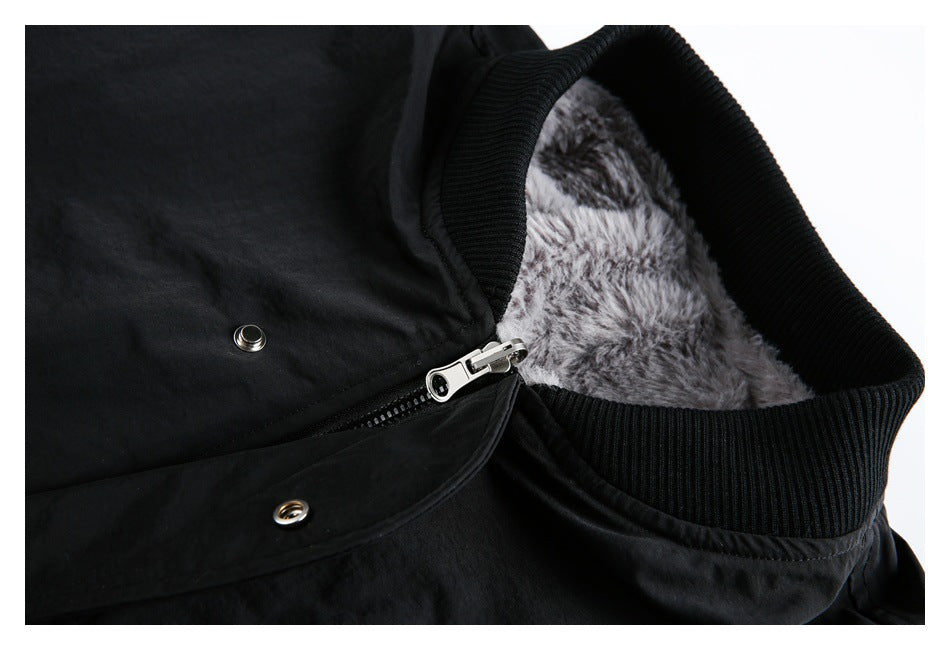 Inside detail of a black garment with gray faux-fur lining, a ribbed collar, zipper and snaps.