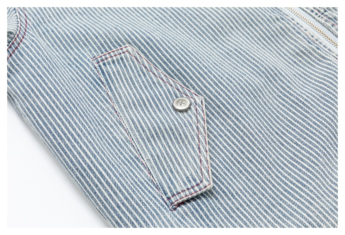 Close-up of a buttoned fabric tab with red stitching on a blue-and-white striped garment.