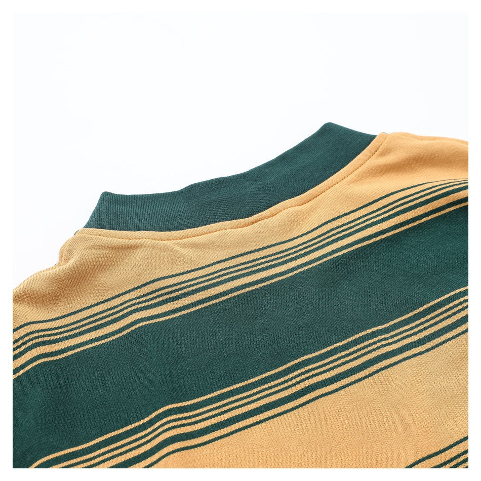 Close-up of a dark green ribbed collar and striped mustard and green garment neckline.