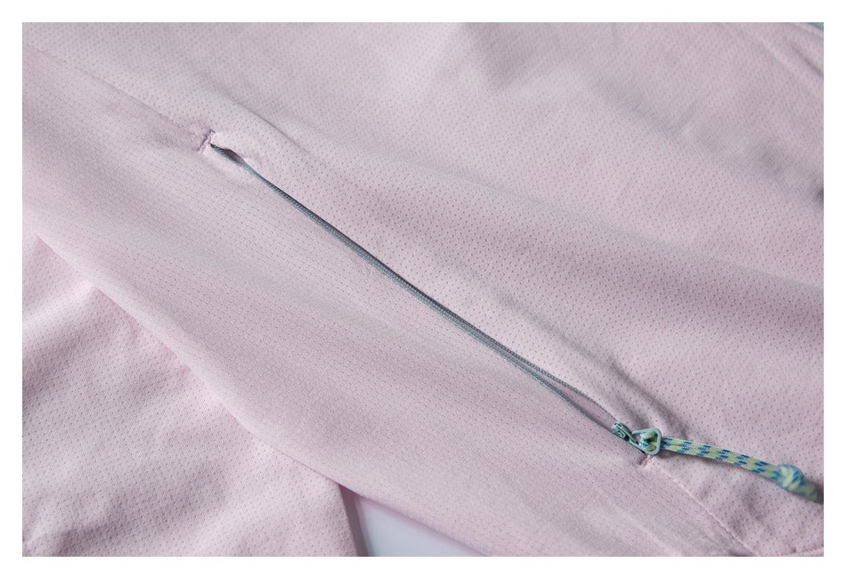 Close-up of a slim zip pocket with a patterned pull cord on the pale pink perforated jacket sleeve.