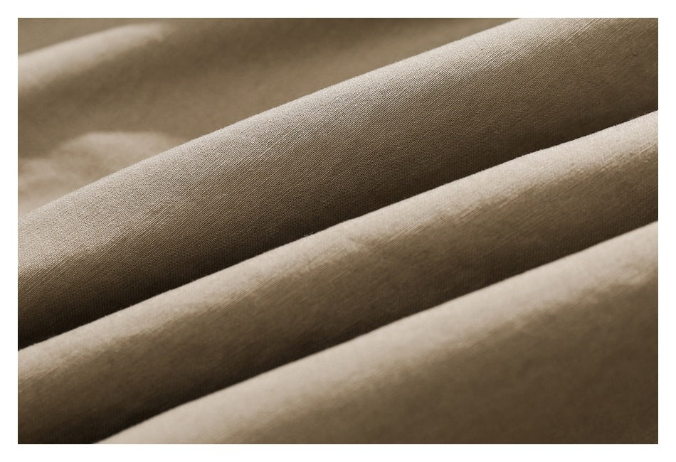 Close-up of khaki fabric arranged in soft folds, showing its fine woven texture.