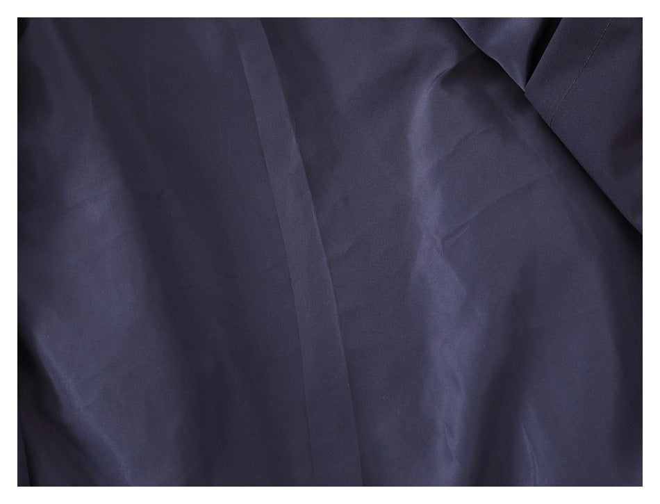 Close-up of dark navy garment fabric with a vertical seam and folded edge.