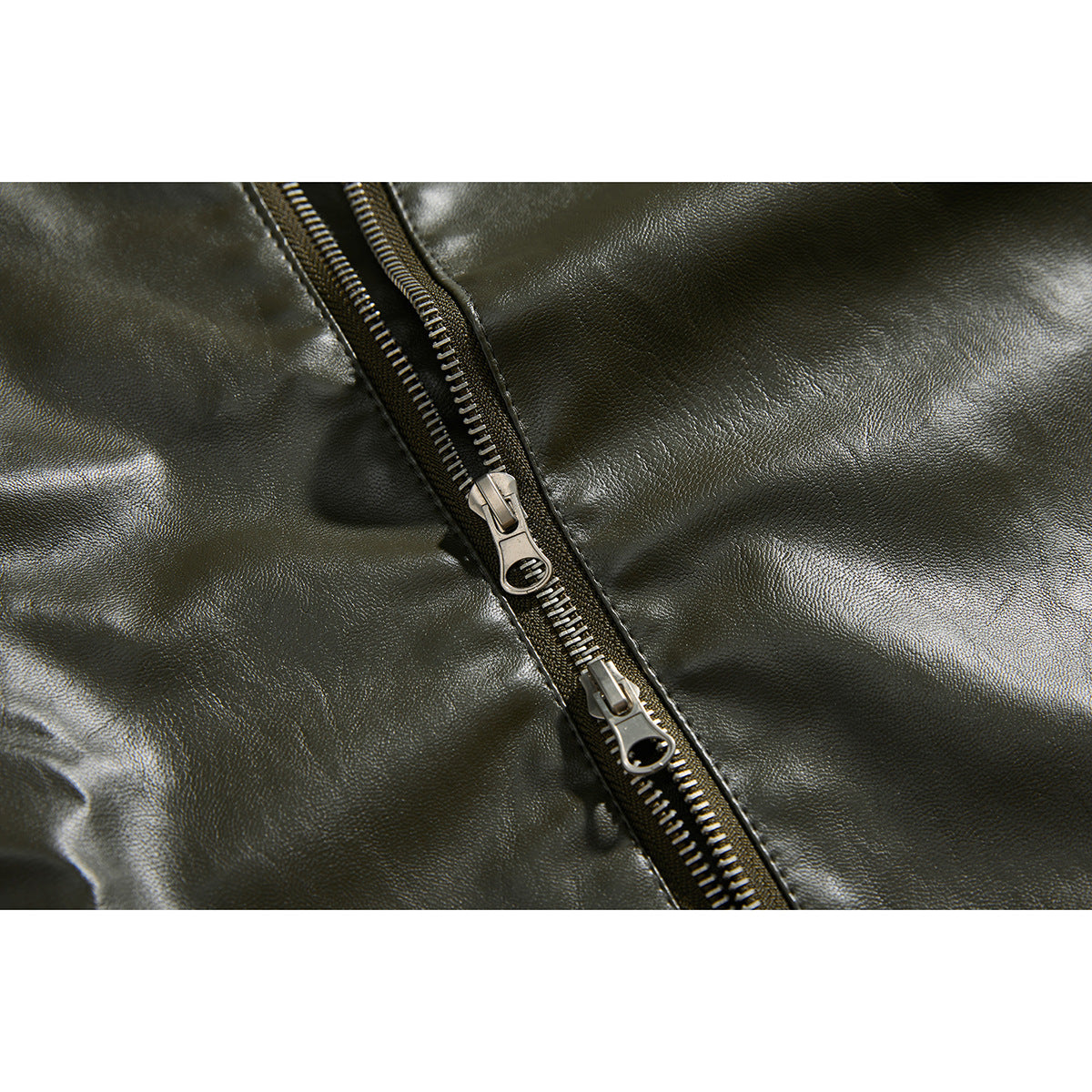 Close-up of the olive jacket's metal front zipper with two sliders.