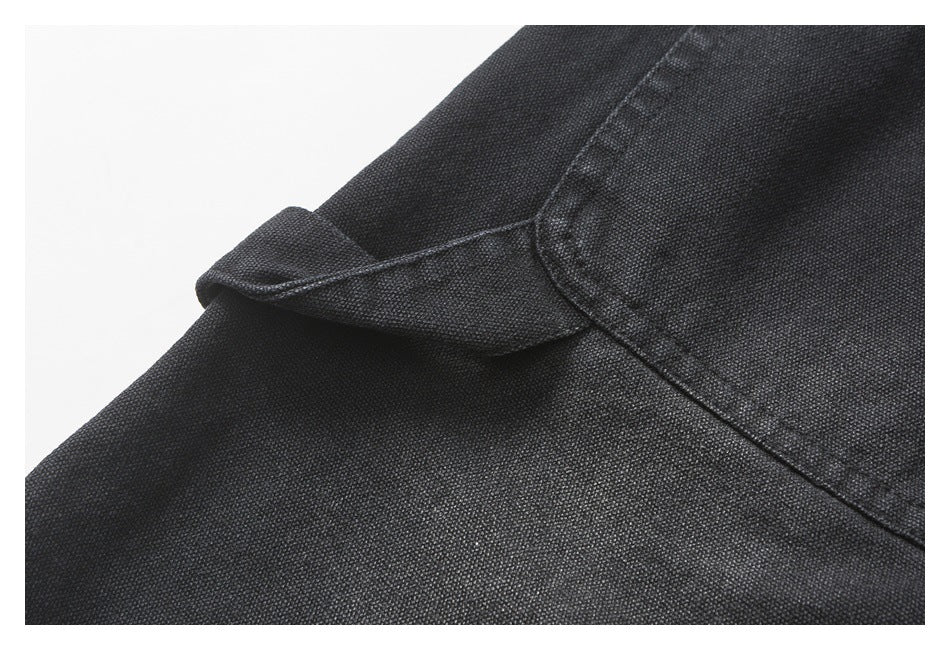 Close-up of black trouser fabric and a folded seam beside a stitched pocket edge.
