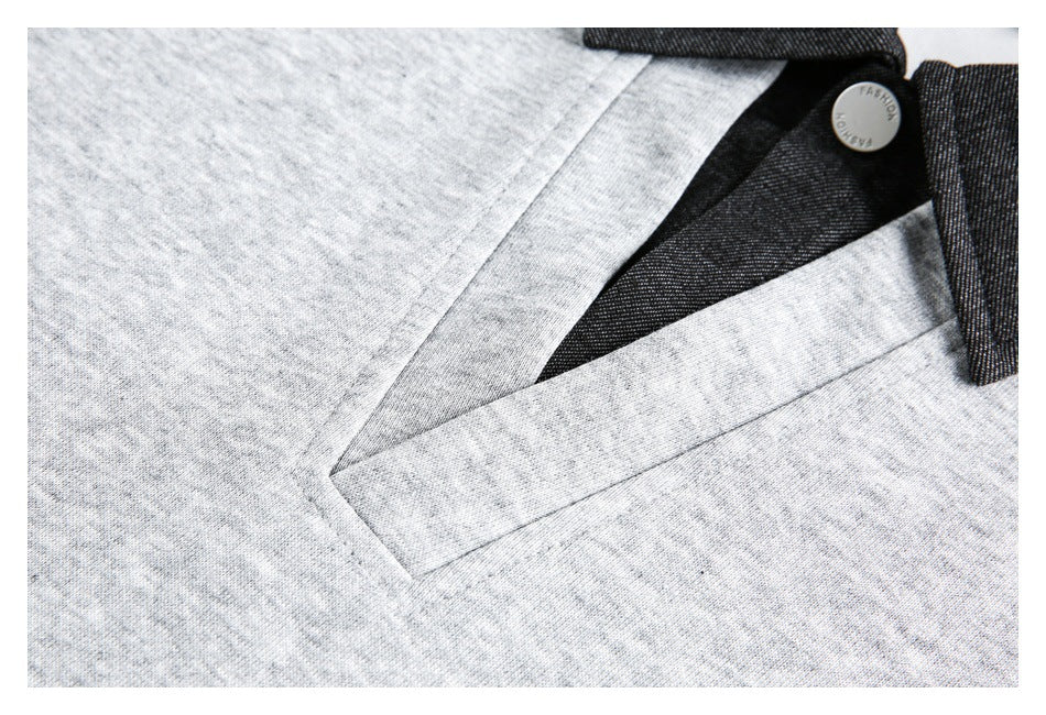 Close-up of a slanted pocket opening with light gray fabric, dark trim, and a metal button.