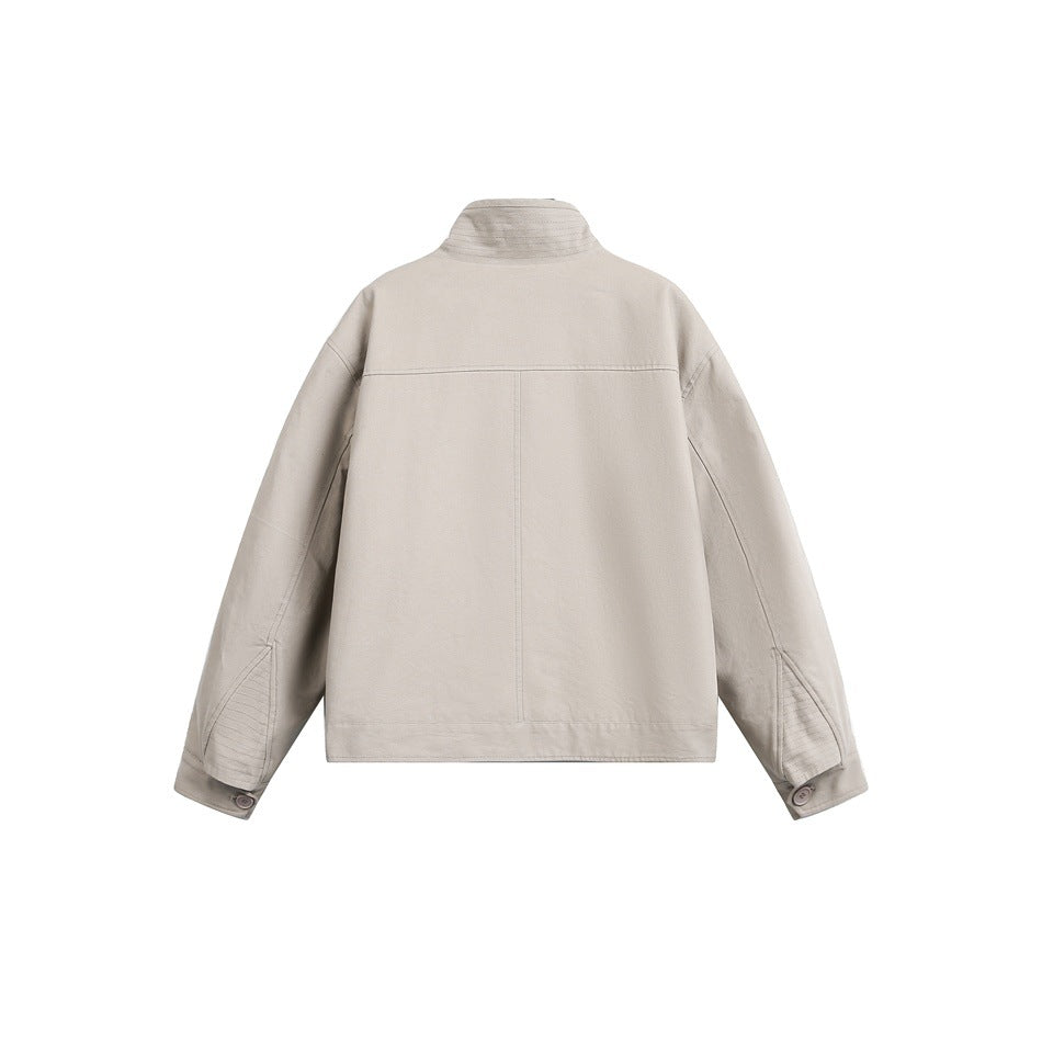 Back view of a light taupe jacket with a high stand collar, seam detailing, and buttoned cuffs on a white background.