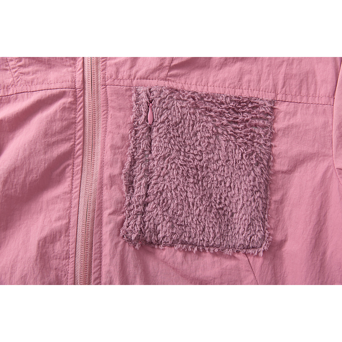 Close-up of a pink jacket chest pocket with a fuzzy flap and zipper beside the front zipper.