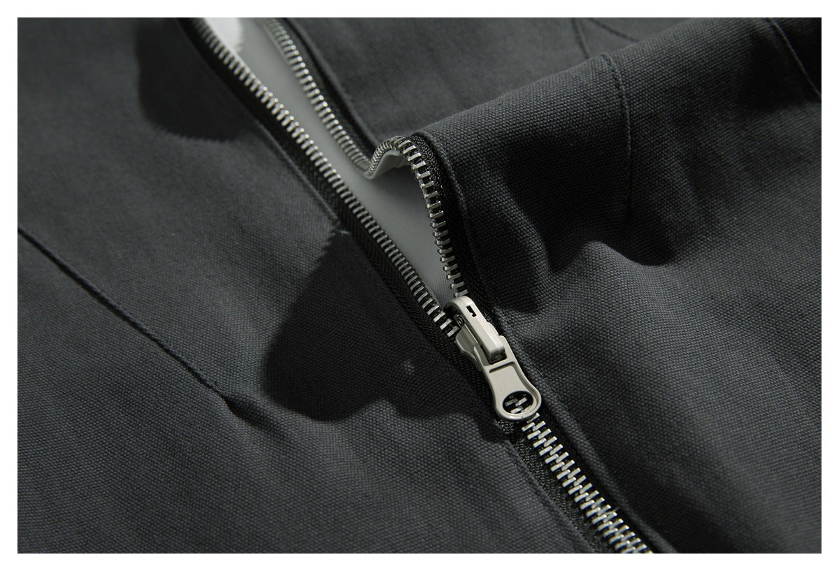Close-up of the metal zipper and textured charcoal fabric on a jacket.