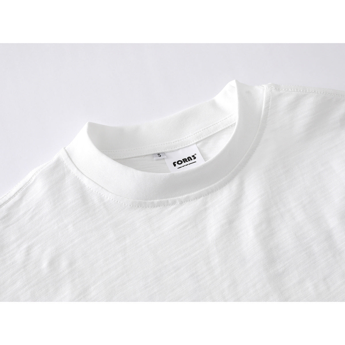 Close-up of a white crew-neck shirt collar with a small size tag and inner label.