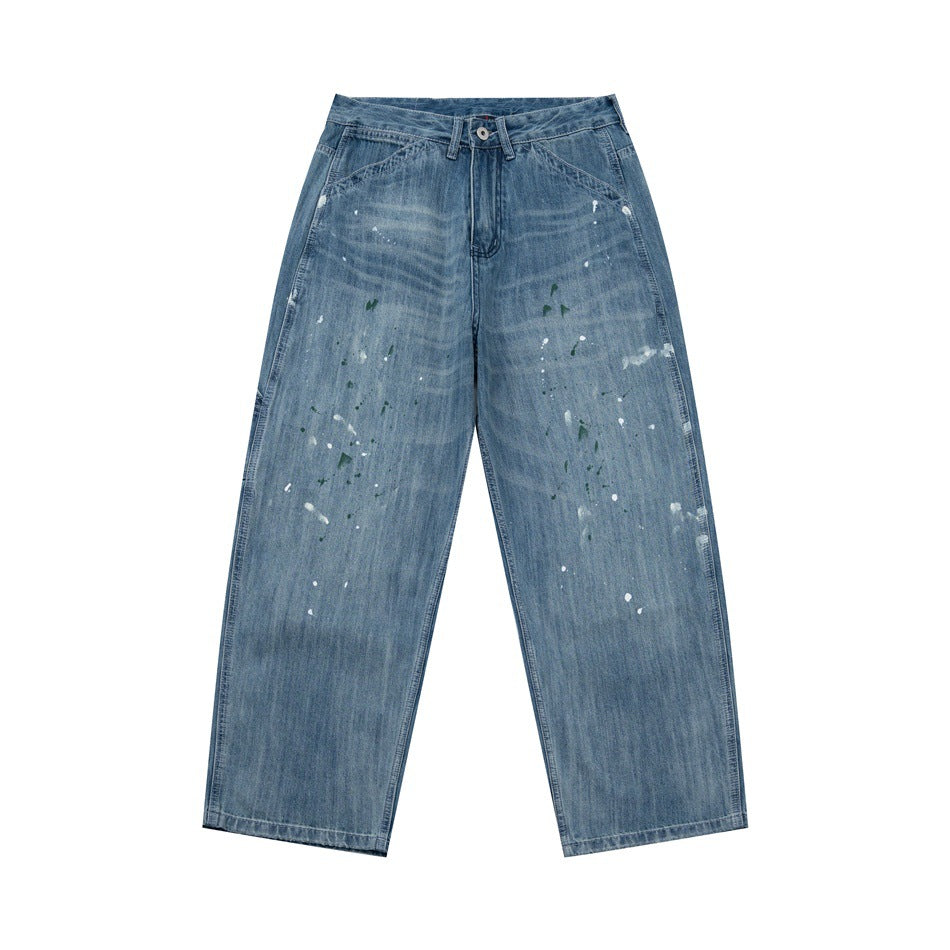 Front view of faded blue wide-leg denim jeans with white and green paint splatters
