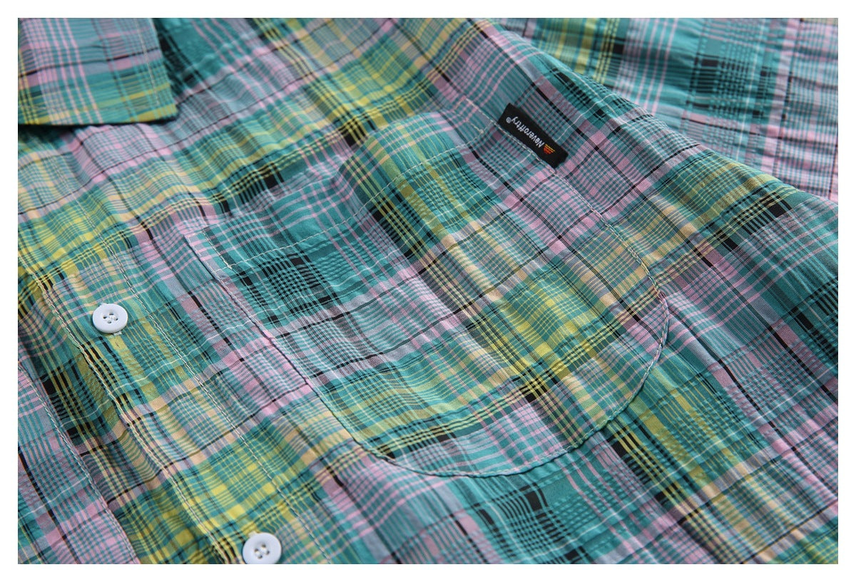 Close-up of a chest pocket, buttons and sewn brand label on the multicolor plaid shirt.