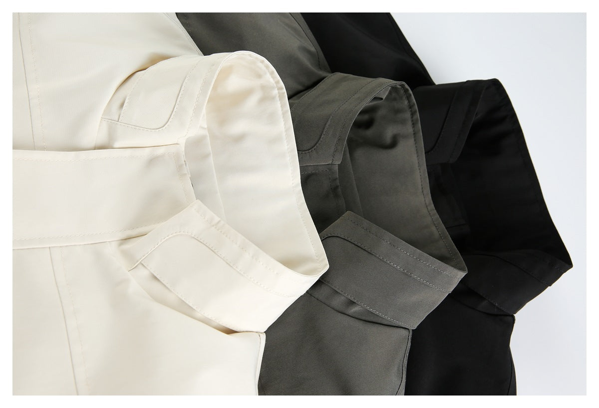 Close-up of cream, dark gray, and black jackets arranged together, highlighting their sleeves and cuffs.
