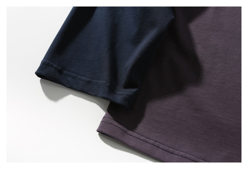Close-up of the navy sleeve and plum shirt body, showing their stitched hems and fabric texture.