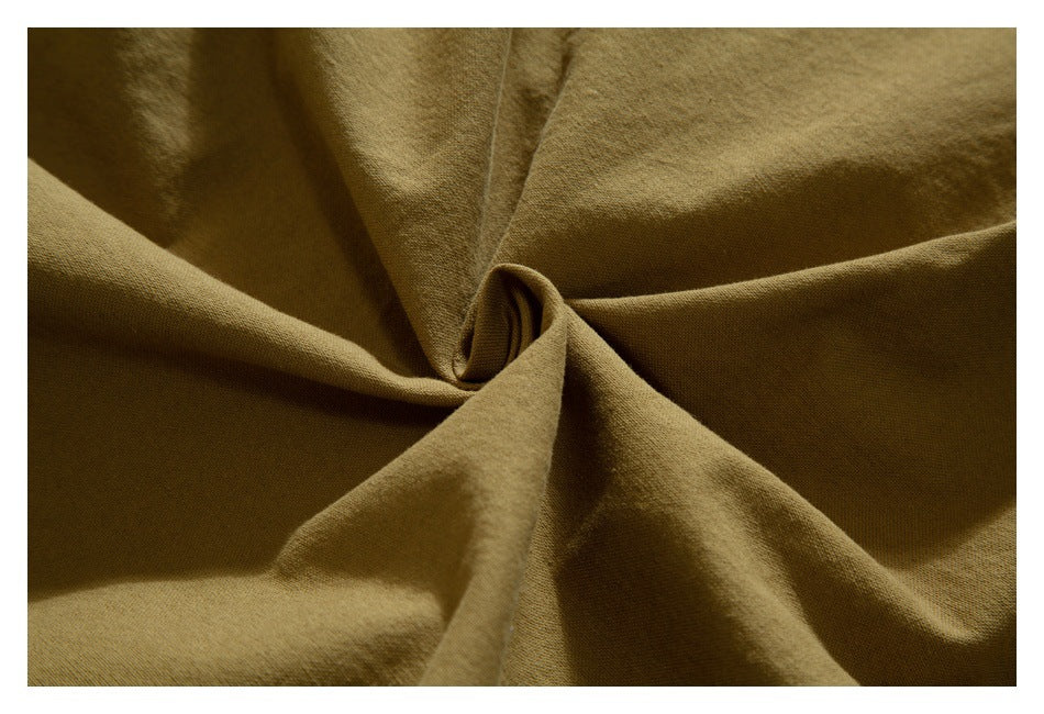 Close-up showing the drape and surface texture of tan garment fabric.