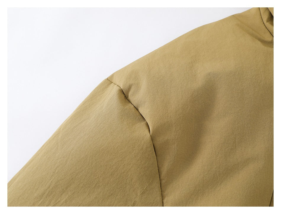 Close-up of the tan jacket's shoulder seam and sleeve construction.