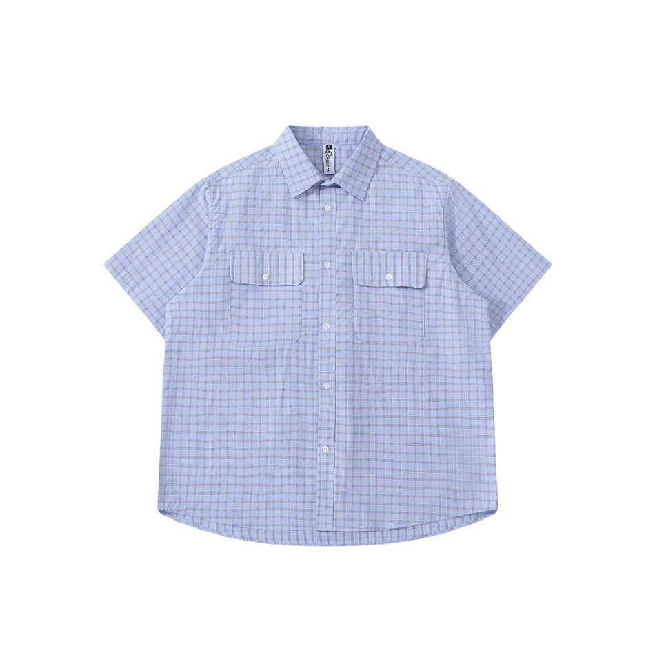 Blue plaid short-sleeve button-up shirt with two chest flap pockets, laid flat, front view