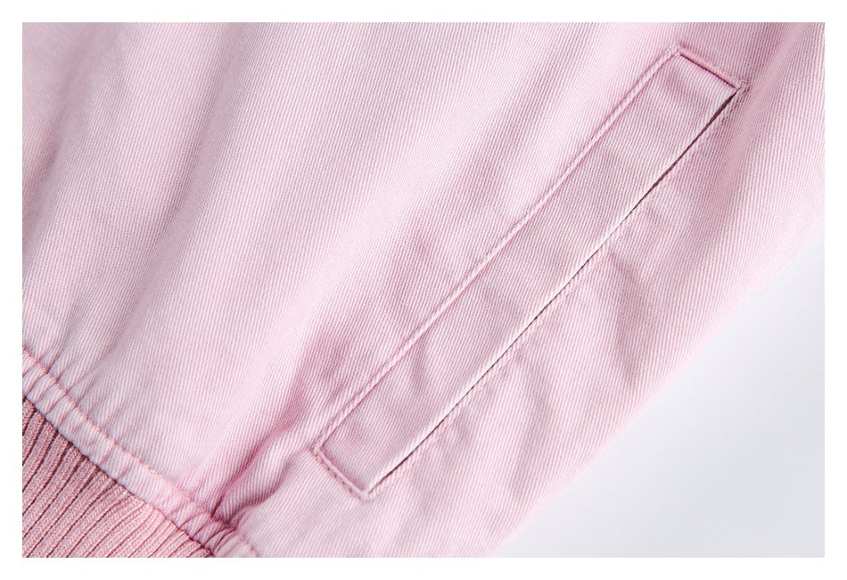 Close-up of a pale pink jacket side welt pocket and ribbed hem.