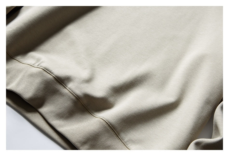 Close-up of light beige sweatshirt fabric and its ribbed hem.