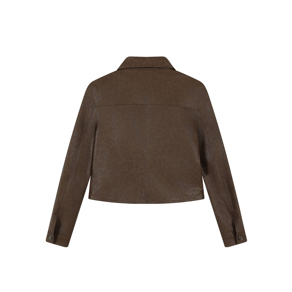 Back view of brown cropped jacket showing yoke seam, center back seam and buttoned cuff tabs