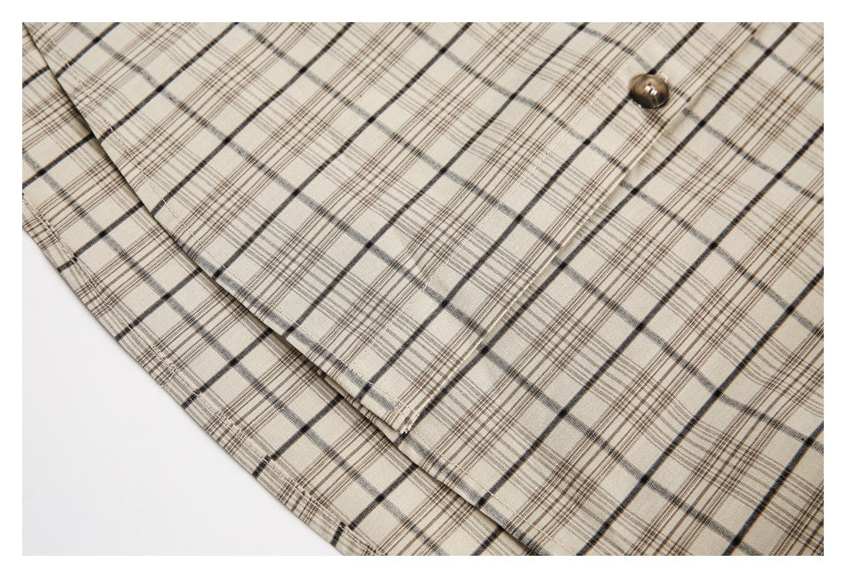 Close-up of a brown button on a beige plaid garment, showing the overlapping front placket.