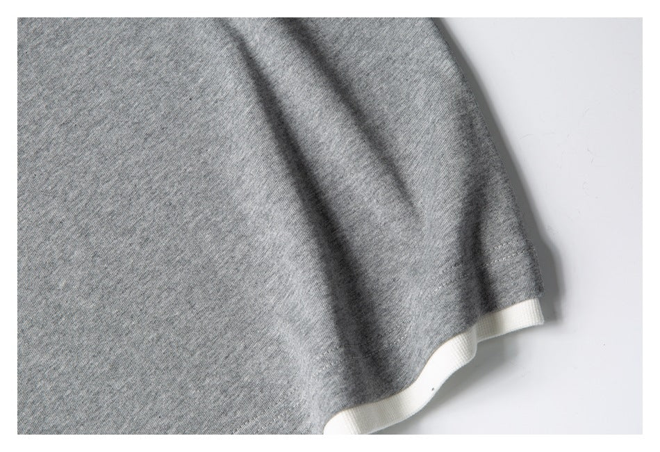 Close-up of a gray sleeve hem with white fabric visible underneath.