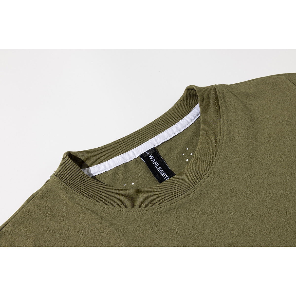 Close-up of an olive-green T-shirt's ribbed crew neck, inner label, and white neck tape.