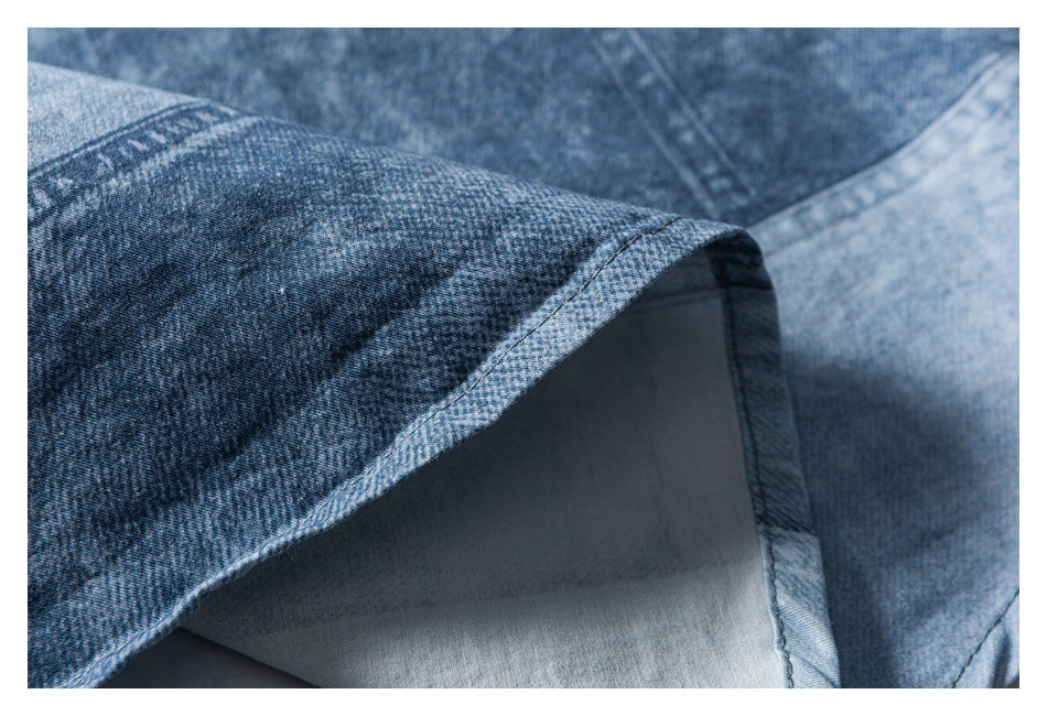 Close-up of a folded, stitched blue denim edge with the lighter reverse side visible.
