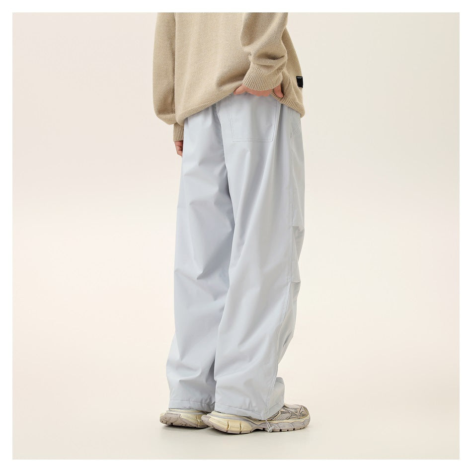 Rear view of a model wearing very light gray loose pants with a back pocket and a beige sweater.