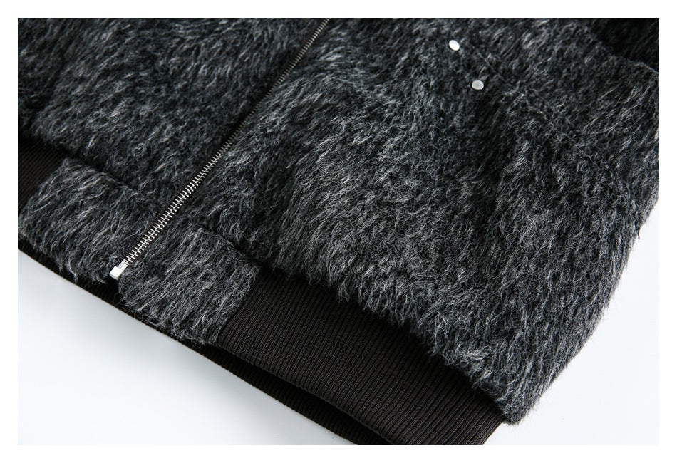 Close-up showing a metal zipper, two silver snaps, and a black ribbed hem on a fuzzy charcoal garment.