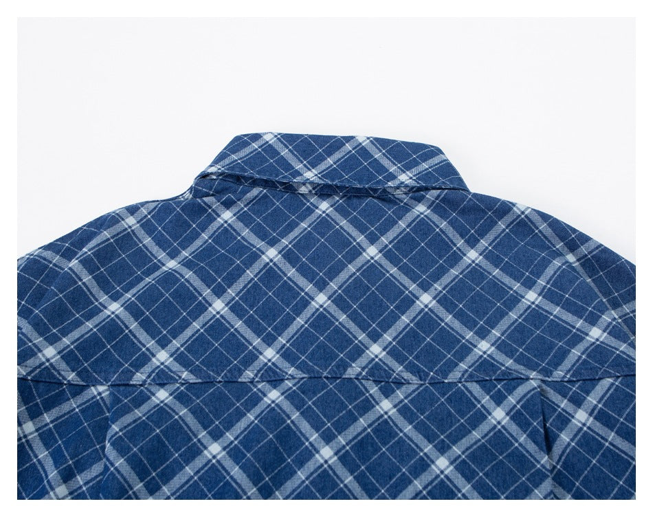 Close-up of the back collar and shoulder yoke on a blue-and-white plaid shirt.