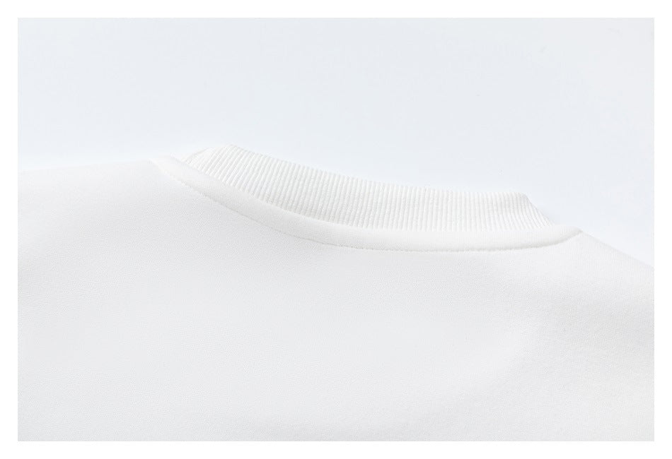 Close-up of the white sweatshirt's ribbed crew neckline and shoulder seam.