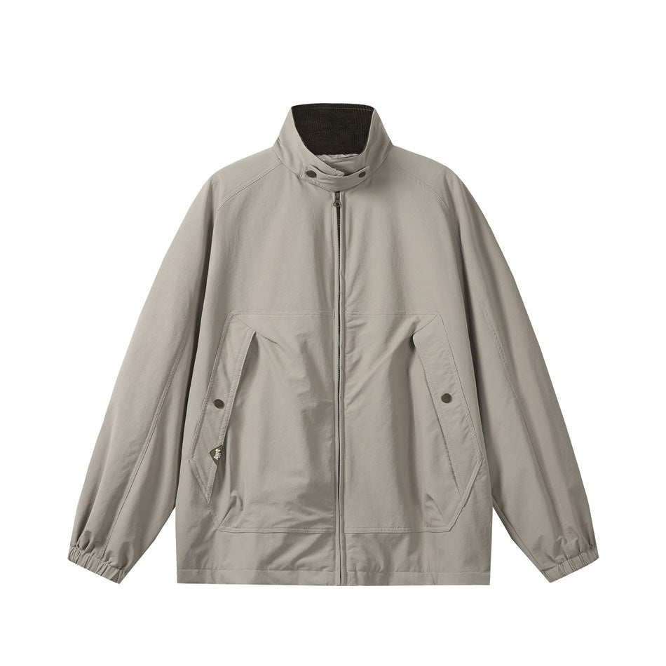 Front view of a light taupe zip-front jacket with a stand collar, angled snap pockets, and elasticated cuffs.