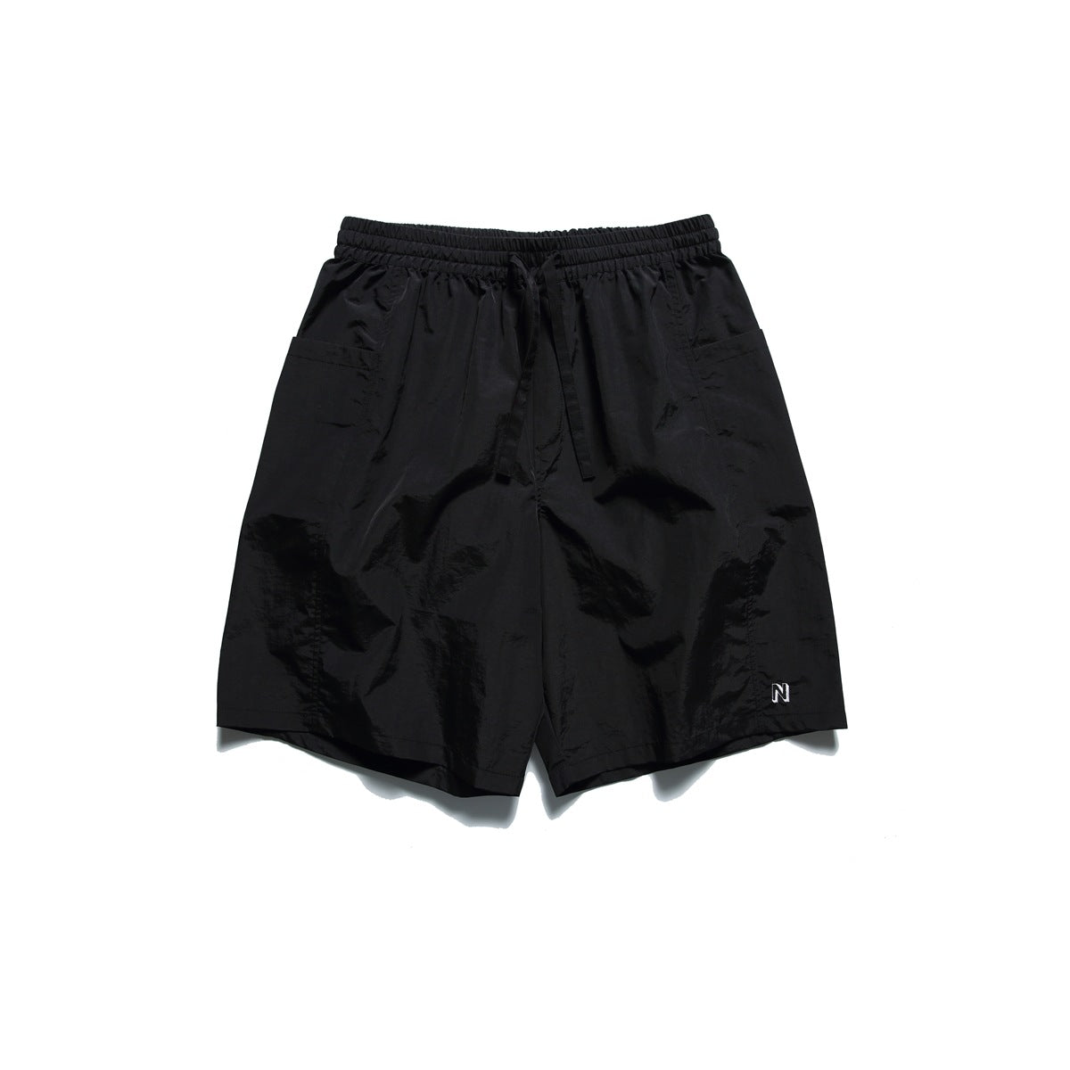 Black knee-length shorts with elastic drawstring waist, side patch pockets and small embroidered N logo, flat lay