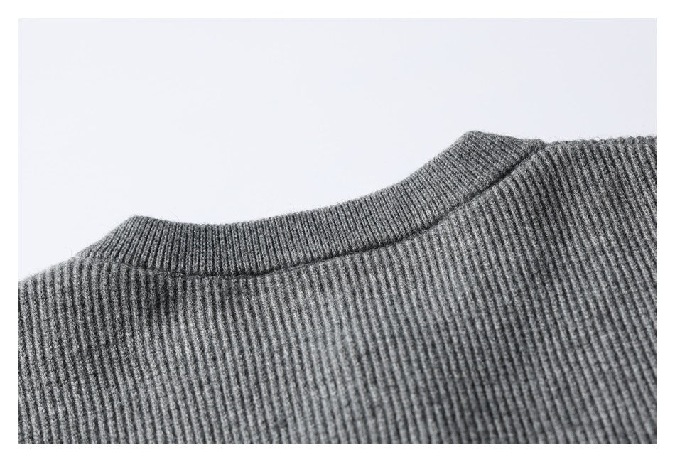 Close-up of the ribbed neckline and upper shoulder of a gray knit garment.