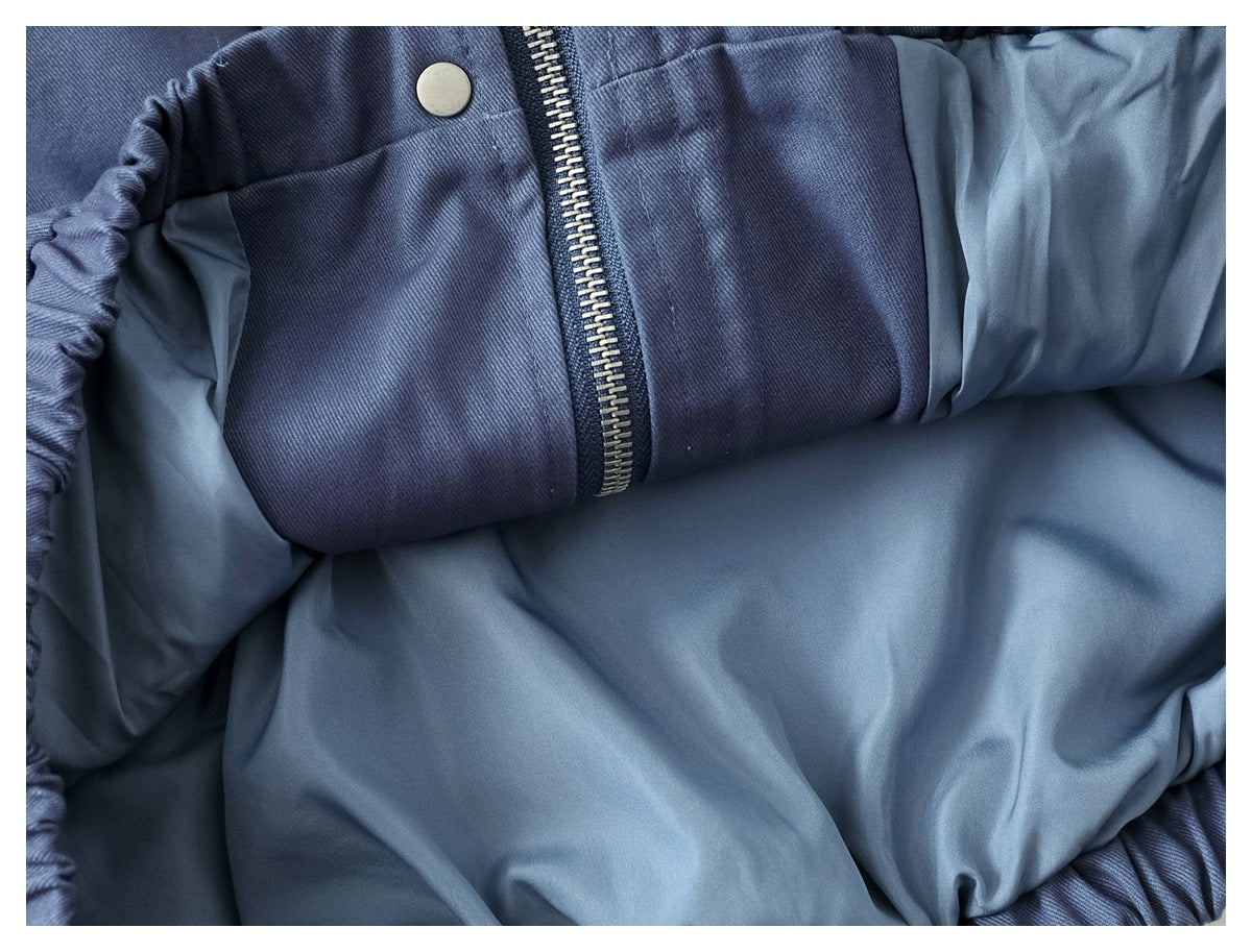 Inside view of the slate-blue jacket showing its lining, zipper, and snap fastener.