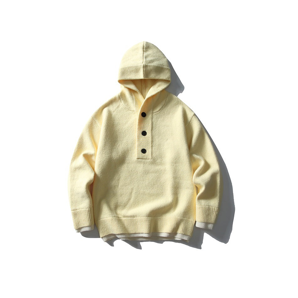 Pale yellow hooded knit sweater with three-button placket and cream layered hem trim, flat lay