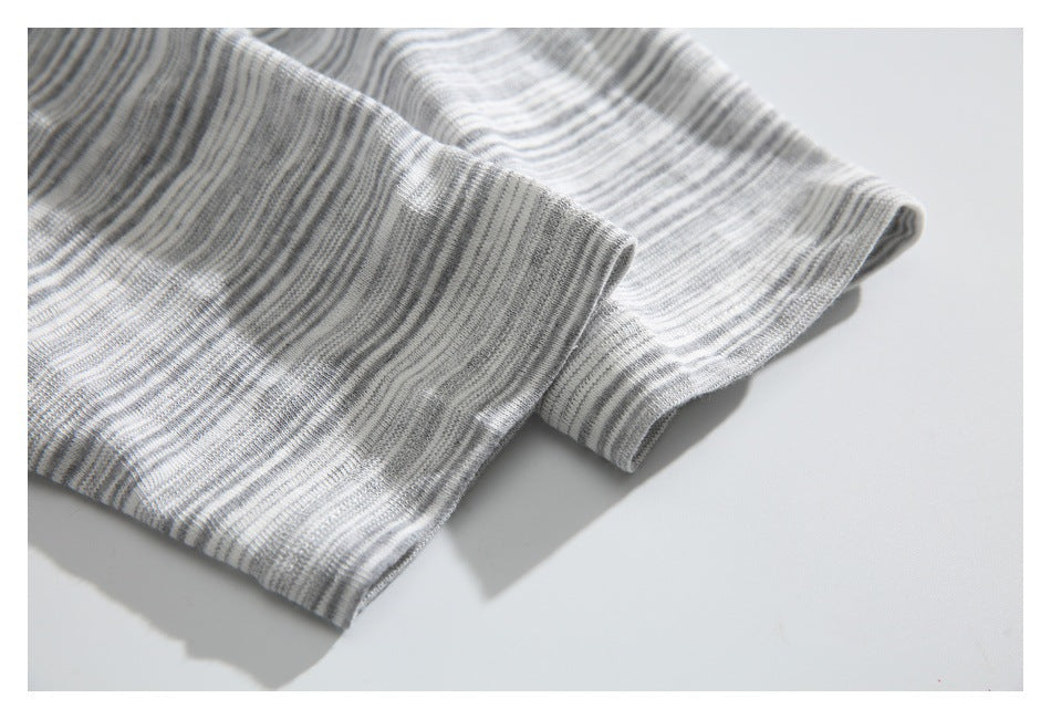 Close-up of gray and white striped knit fabric with a folded edge.