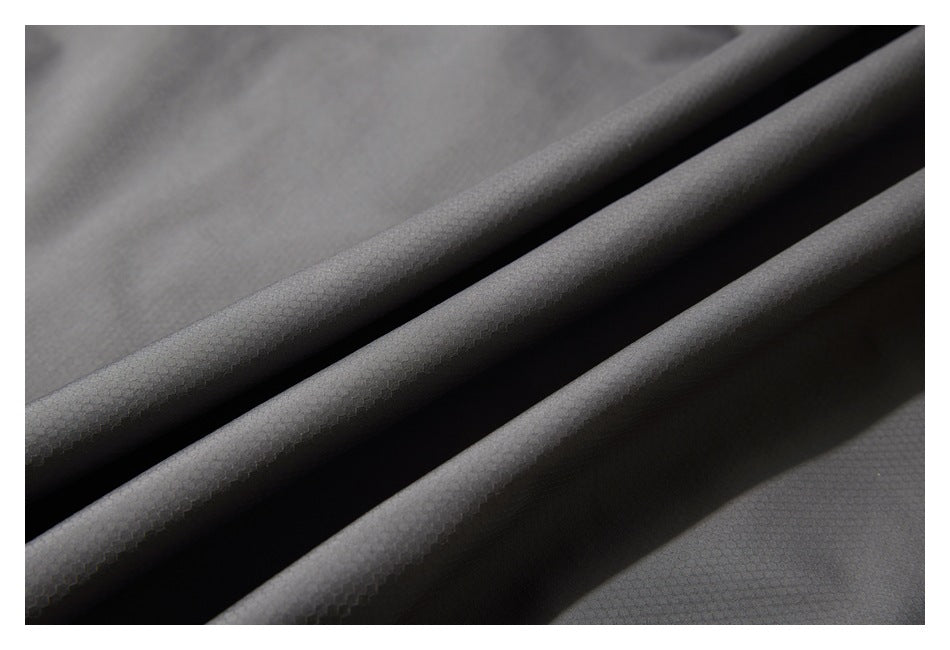 Close-up of dark gray fabric draped in folds, showing a subtle small-scale texture.