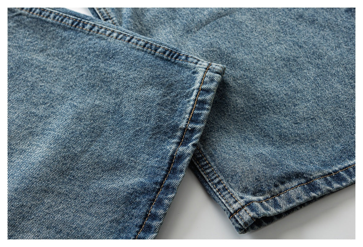 Close-up of faded blue denim hems with visible stitching and folded edges.