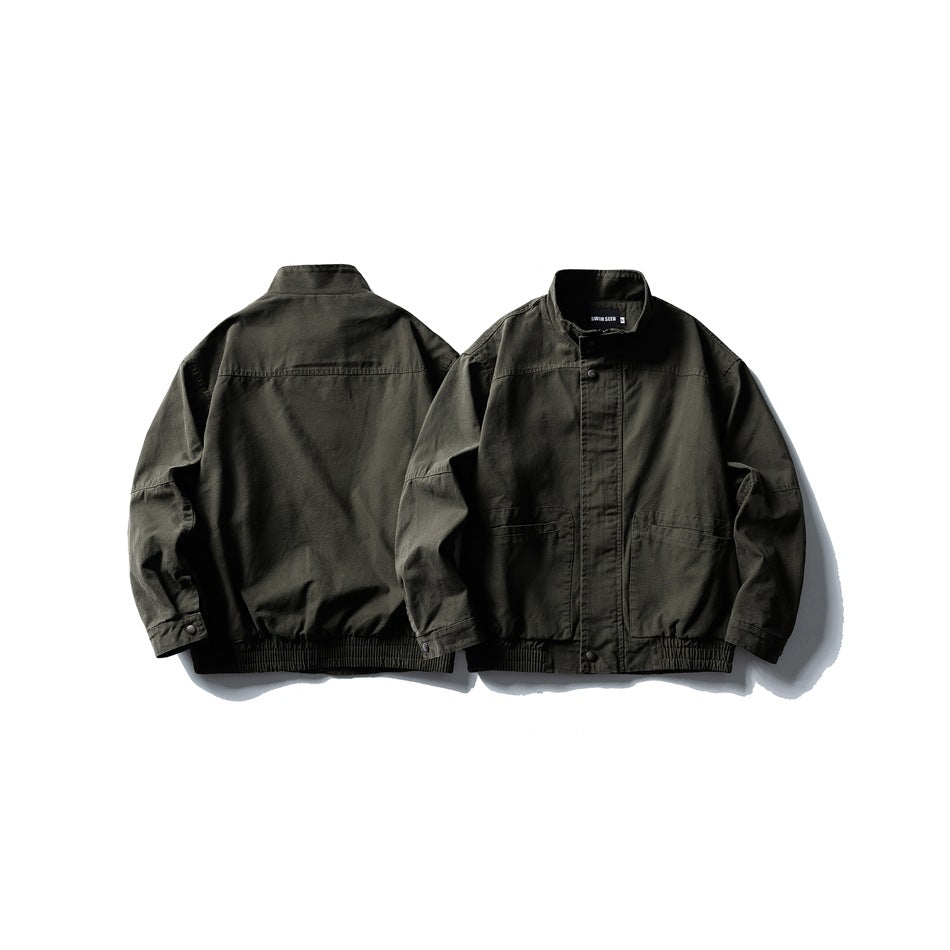 Olive drab jacket shown from front and back, with a stand collar, snap closure, front pockets and elasticated hem.