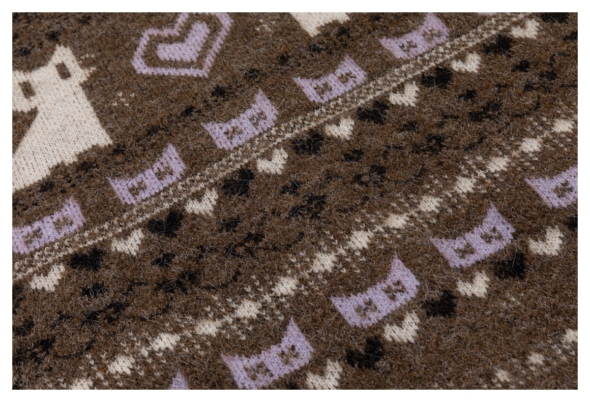 Close-up of the brown cardigan's all-over knit pattern with cream and lavender motifs and dark accents.