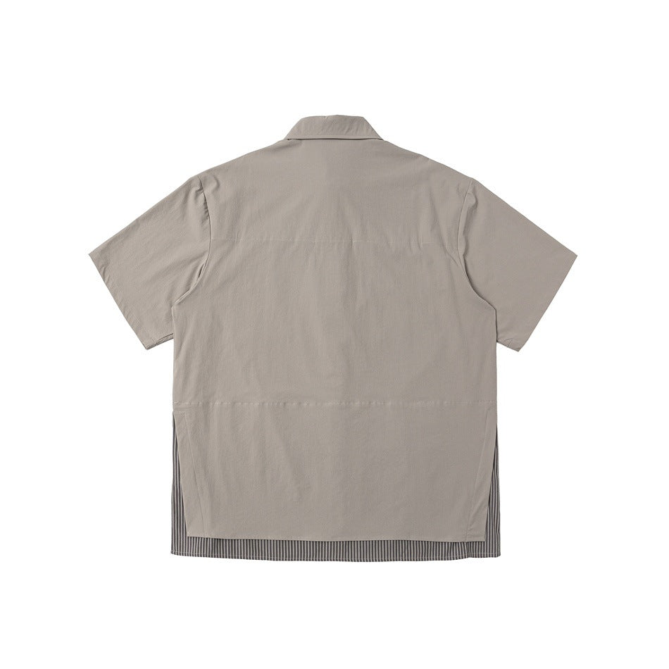 Back view of a taupe short-sleeve shirt with a striped inset visible along the hem.
