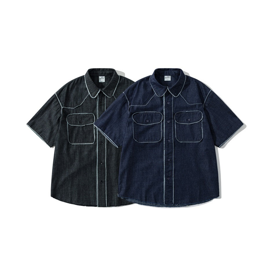 Two short-sleeve denim button-up shirts shown from the front in charcoal and dark indigo, with contrast stitching and chest