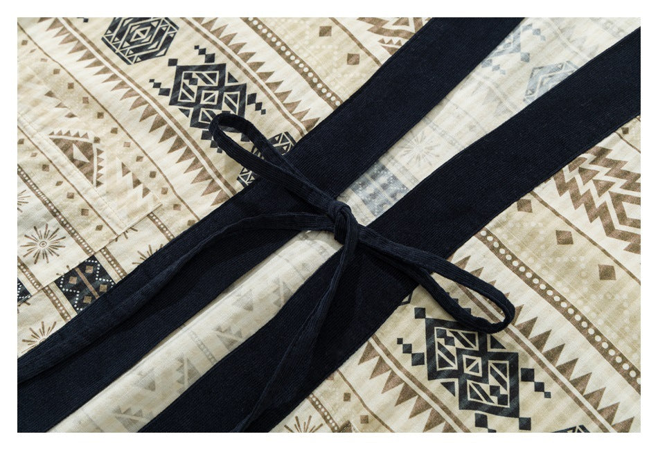 Close-up of a dark navy waist tie knotted over a beige garment with brown and navy geometric patterns.