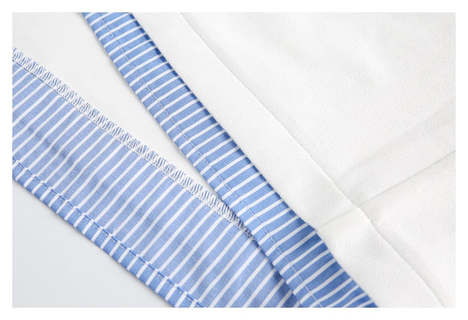 Close-up of white garment construction with blue-and-white striped fabric and visible stitching.